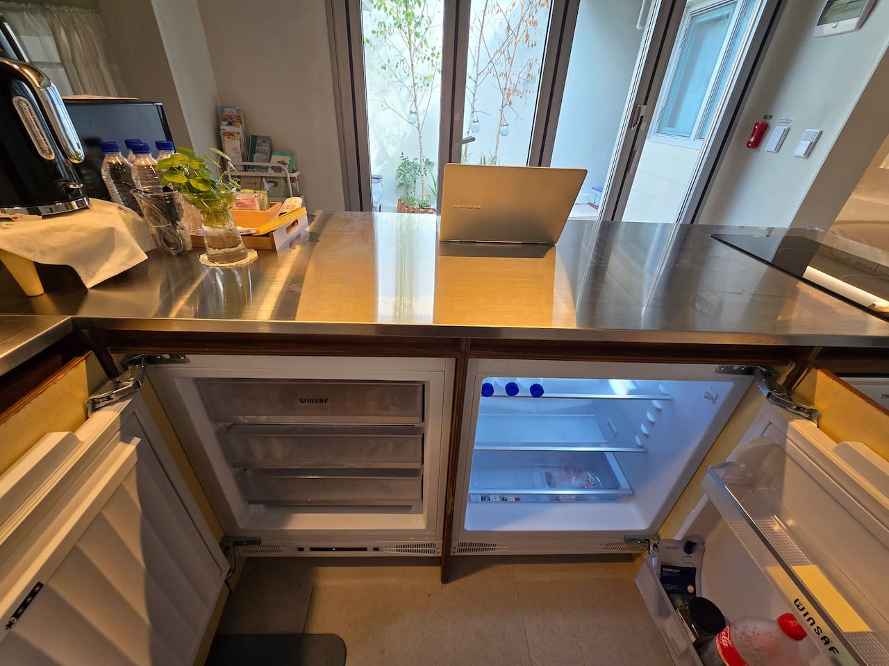 스테인레스스틸 카운터 아래에 냉동고, 냉장고가 설치돼 있습니다. 